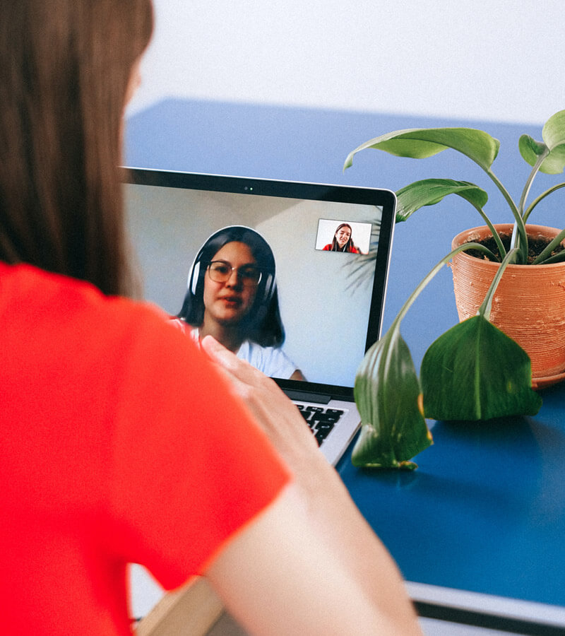 An image of a web consultant on a video call with a prospective client discussing web design case studies.