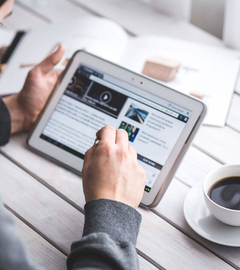 An image of a man on a tablet looking at domain names for an upcoming website project with Not Fade Away Web Design and Marketing. 