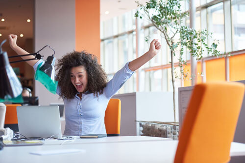 An image of an excited customer celebrating the responsive west palm beach web design services she received at Not Fade Away.