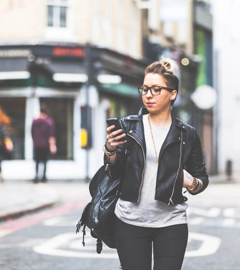 An image of a woman looking on a phone for a local small business optimized for Local SEO. 